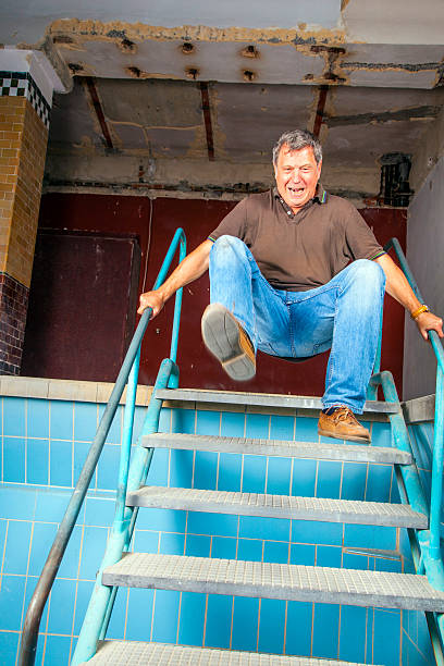 istock man jumping down the stairs of an old waterless pool 470094879