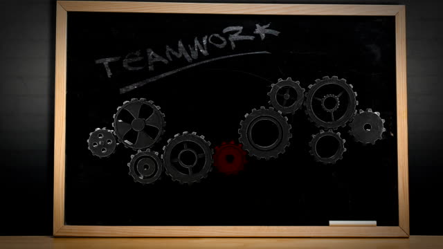 Cogs and wheels turning on blackboard