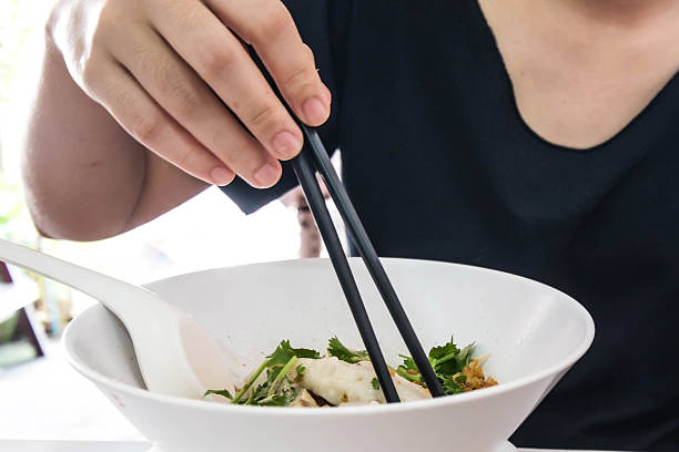teenager eating Thai noodle