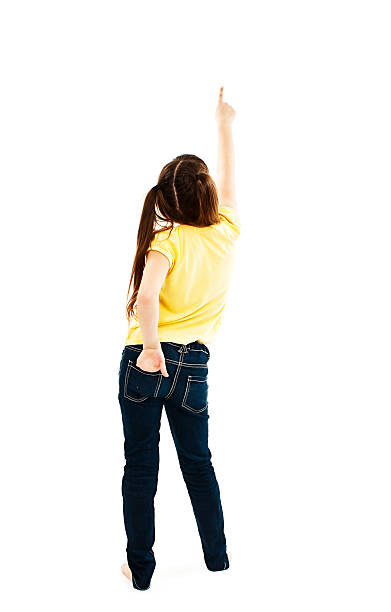 istock Back view of little girl points at wall. Rear view 470100766
