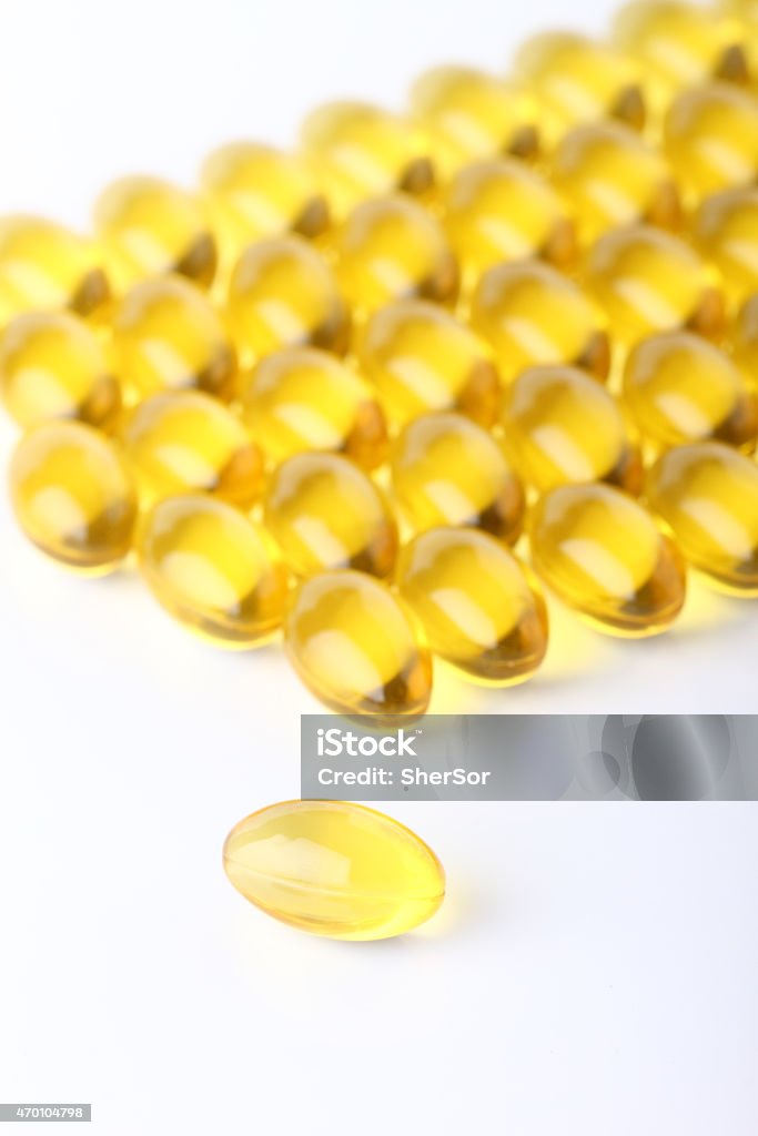 composition of gel capsules Macro view of Cod liver oil omega 3 gel capsules on vitamins line up in background 2015 Stock Photo