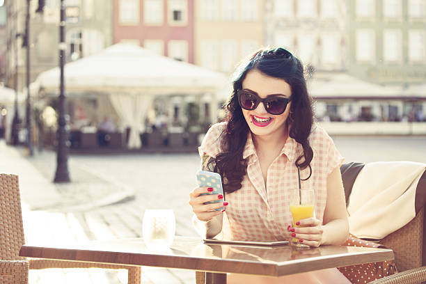 istock Young woman using smart phone in outdoor restaurant 470111620