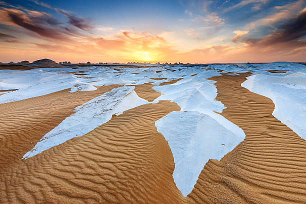 Sunset over The Western Sahara Desert in Africa Sunset over  The White Desert, part of The Western Sahara Desert in Egypt. The White Desert of Egypt is located 45 km (28 mi) north of the town of Farafra. The desert has a white, cream color and has massive chalk rock formations that have been created as a result of occasional sandstorm in the area.http://bem.2be.pl/IS/egypt_380.jpg egypt horizon over land sun shadow stock pictures, royalty-free photos & images