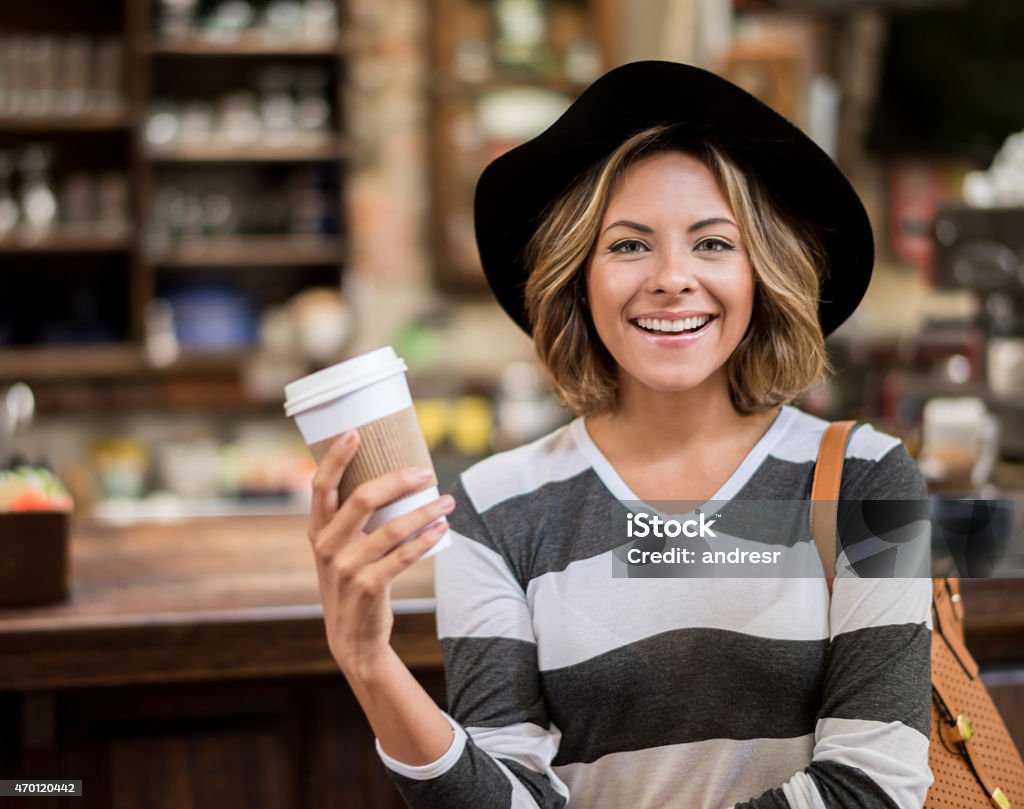 Woman taking a coffee to go Happy woman at a cafe taking a coffee to go Paper Coffee Cup Stock Photo