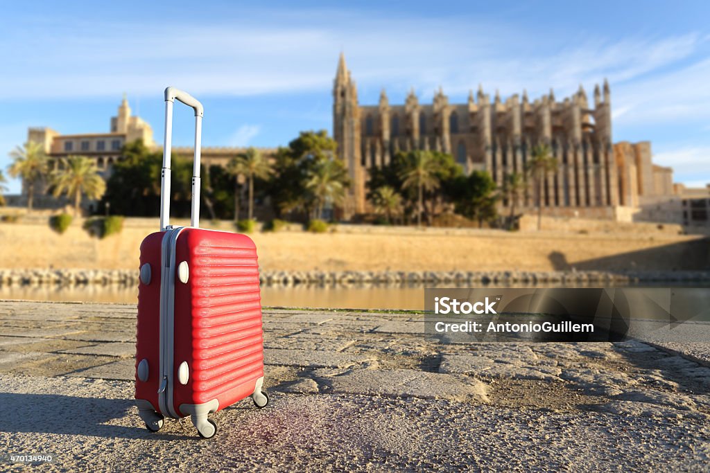 Tourist concept with a suit case in a touristic place Tourist concept with a suit case in a touristic place with a cathedral in the background 2015 Stock Photo
