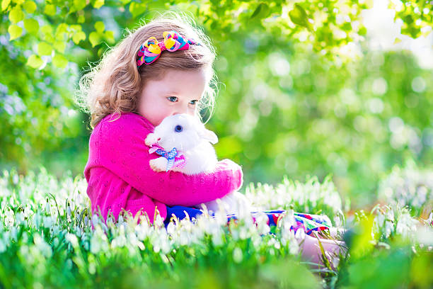 istock Sweet little girl playing with a rabbit 470138350