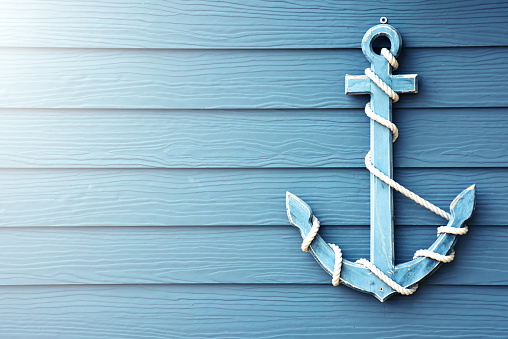 Beautiful anchor on blue wooden background.
