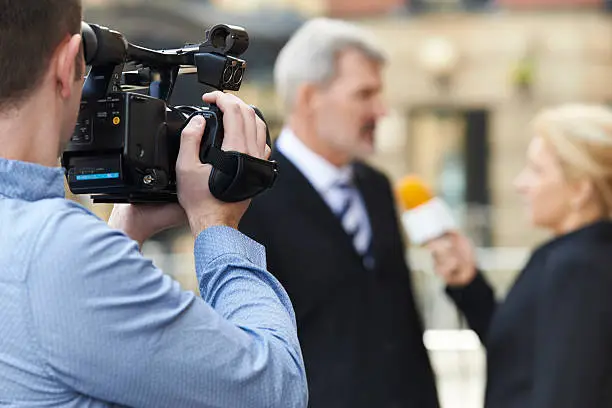 Cameraman Recording Female Journalist Interviewing Businessman