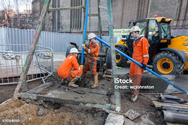 Workmen In Orange Overalls Stock Photo - Download Image Now - 2015, Agricultural Machinery, Bib Overalls