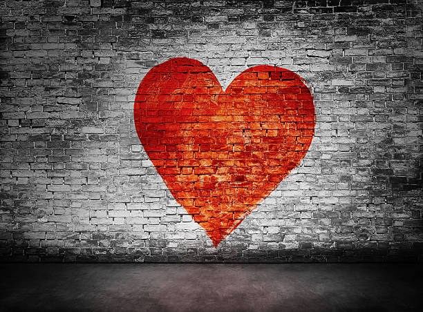 Symbol of love painted on murky brick wall Symbol of love painted on murky, sullen brick wall graffiti brick wall dirty wall stock pictures, royalty-free photos & images