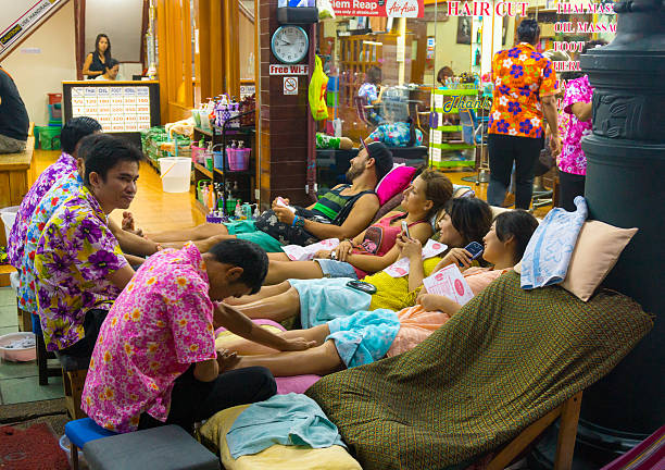 Phuket, Thailand, February 20, 2018: Employees sit at the entrance to the massage parlor and await customers.