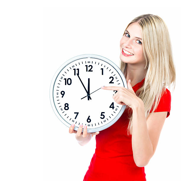 istock time concept. five to twelve. young beautiful woman. big clock 470151305