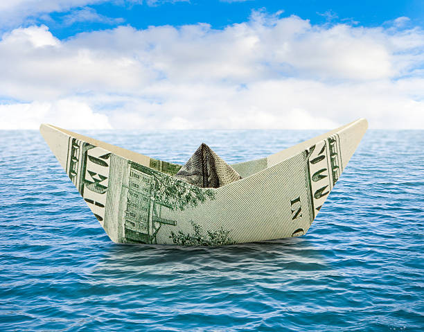 istock Ship from money on water 470152356
