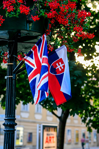 Bratislava, Slovakia - July 13, 2012: British and Slovakia flags hang side by side from a lamp post in Bratislava