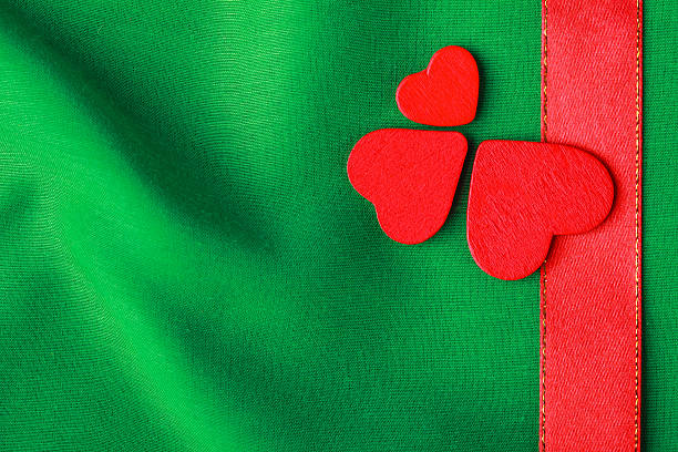 istock Red wooden decorative hearts on green cloth background 470155183