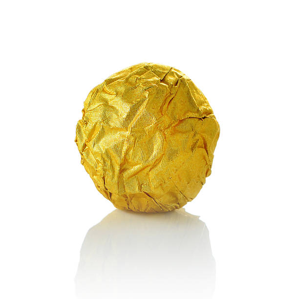 bola de almendras de chocolate en oro con una lámina de papel. - gold carbohydrate food food and drink fotografías e imágenes de stock