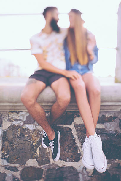 borrosa hipster pareja romántica en una pared de piedra agarrar de la mano - couple old fashioned hipster holding hands fotografías e imágenes de stock