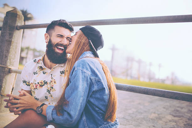 hipster girlfriend playfully morder su novio's cheek - couple old fashioned hipster holding hands fotografías e imágenes de stock