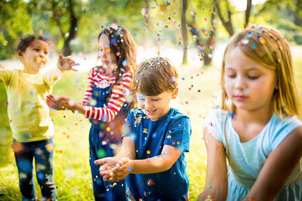 istock Friendly kids having fun with confetti in a park 470157172