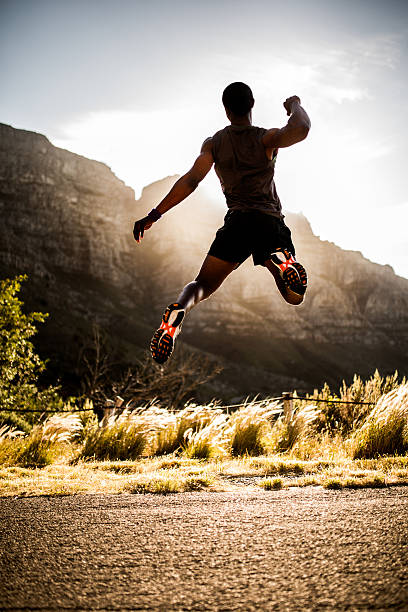 istock Fit joyful athlete leaping into the air in triumph 470157692