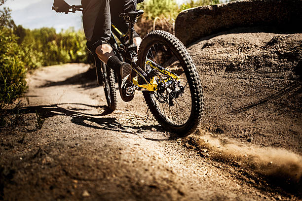 Mountain bike riding on dirt road showing it's tire tread Trail riding mountain bike on a dirt road leaving dust behind and showing it's tire tread mountain bike stock pictures, royalty-free photos & images