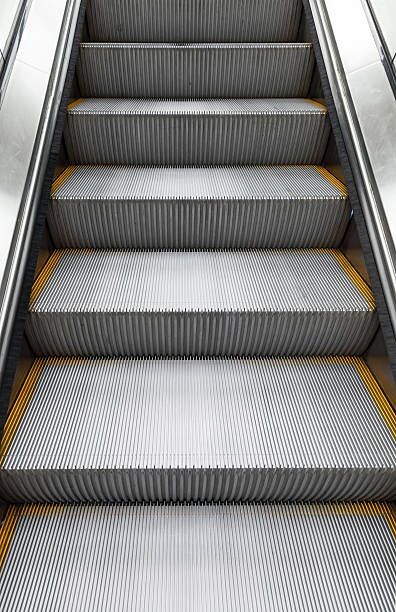 istock Shining metal escalator moving up, vertical photo 470162344