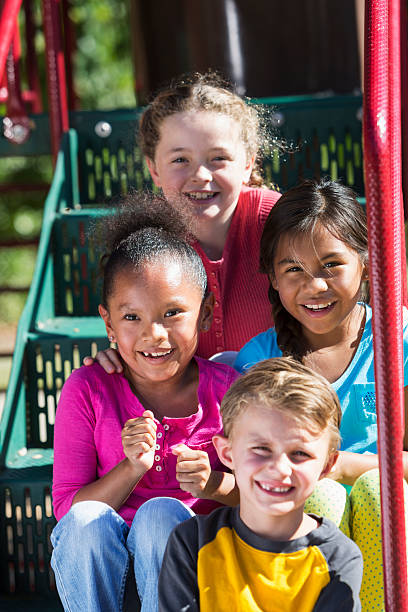 istock Four multi-ethnic children sitting on playground steps 470162994