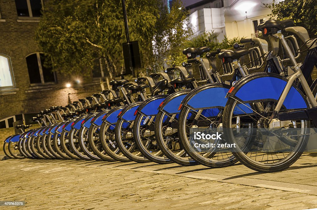 London with bicycles docks stations, England London City Bike Rental - Stock Image. Row of bikes for hire as part of a new scheme to encourage "pedal power" in the City of London. The aim is to reduce dependance on cars and thereby reduce London's polution, emission of greenhouse gases, conserve energy and of course to promote a healthier lifestyle. Sponsor's branding carefully removed. Santander Cycles Stock Photo