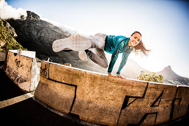 teen breakdance chica haciendo un salto parkour a una pared - carrera urbana libre fotografías e imágenes de stock