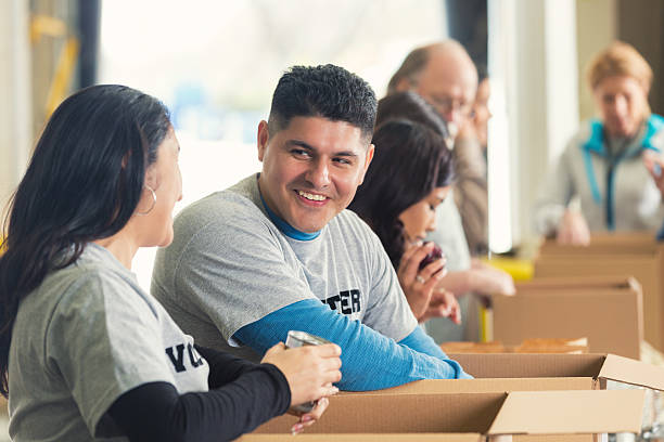 istock Hispanic man sorting donations in food bank with volunteers 470163742