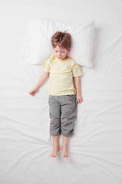 istock Top view of little boy sleeping in Soldier pose 470163970