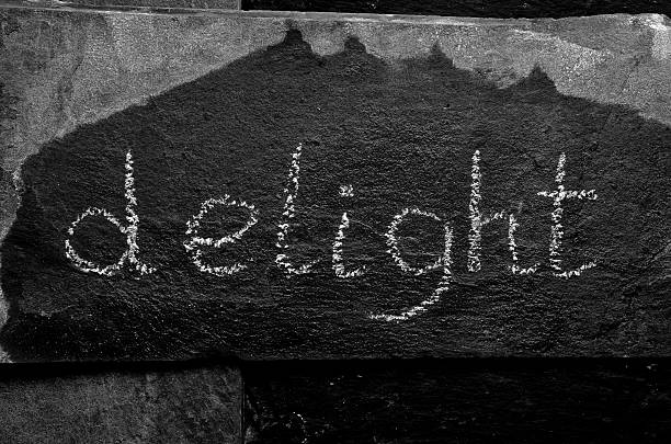 istock The word DELIGHT written with chalk on black stone. 470167028