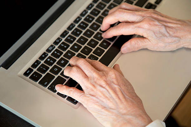 istock Senior wrinkled hands on laptop typing 470167415