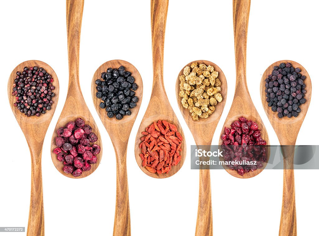 dried superfruit berry set healthy dried berry collection (blueberry, mulberry, cherry, goji, elderberry, chokeberry, cranberry) on isolated wooden spoons, top view Dried Food Stock Photo