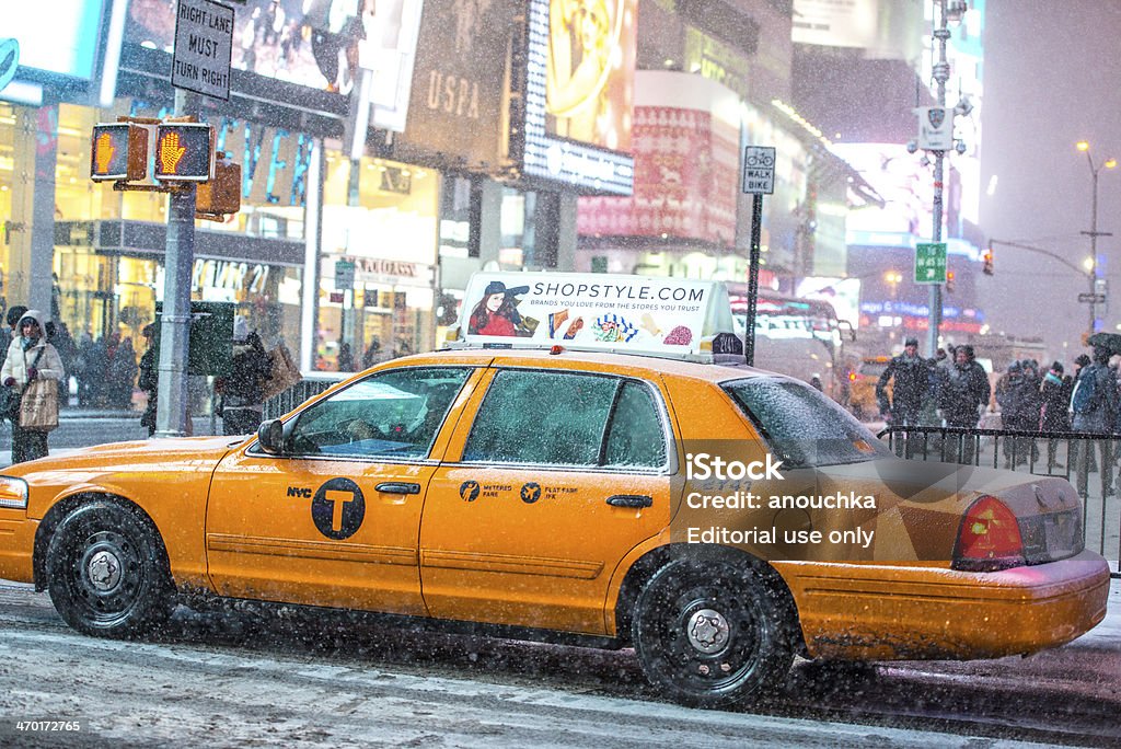 Yellow Taxi in snow blizzard on Times Square, New York New York, USA - January 2, 2014: Yellow Taxi in snow blizzard on Times Square, New York. People enjoying snowfall on Times Square. New York City Stock Photo