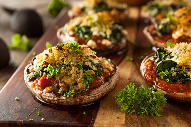 Homemade Baked Stuffed Portobello Mushrooms on wood board Homemade Baked Stuffed Portabello Mushrooms with Spinach and Cheese stuffed photos stock pictures, royalty-free photos & images