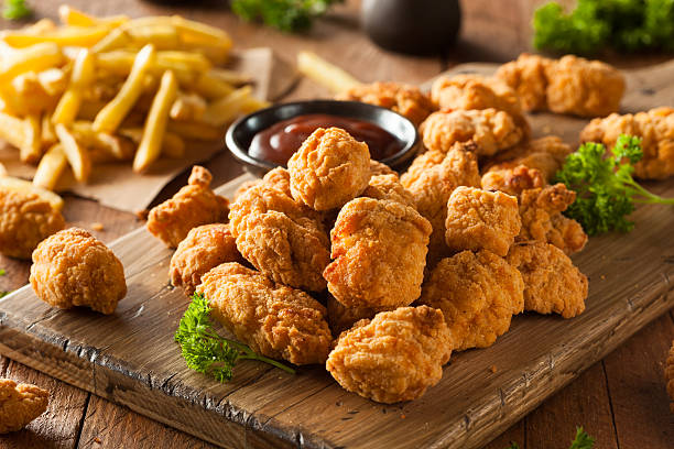 Homemade Crispy Popcorn Chicken Homemade Crispy Popcorn Chicken with Barbecue Sauce crispy chicken nuggets stock pictures, royalty-free photos & images