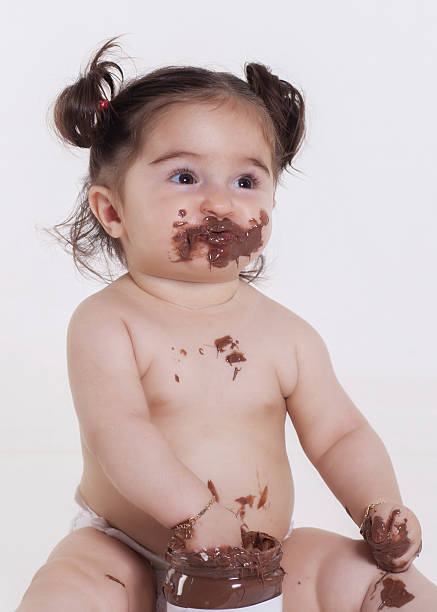 istock baby with chocolate smeared all over her face 470178316