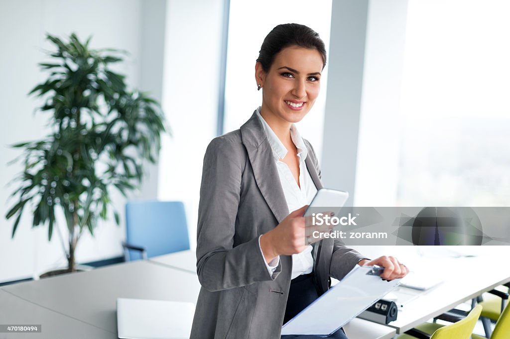 Successful businesswoman Confident beautiful businesswoman texting, using smart phone, looking at camera, copy space 2015 Stock Photo