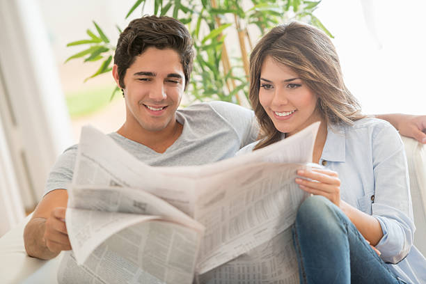 istock Loving couple reading the newspaper at home 470180528