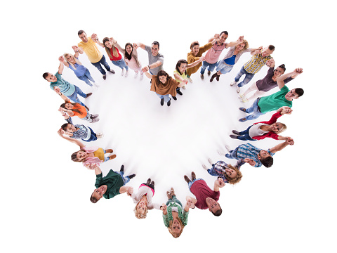 High angle view of large group of happy people holding hands and making heart shape. They are looking at the camera.