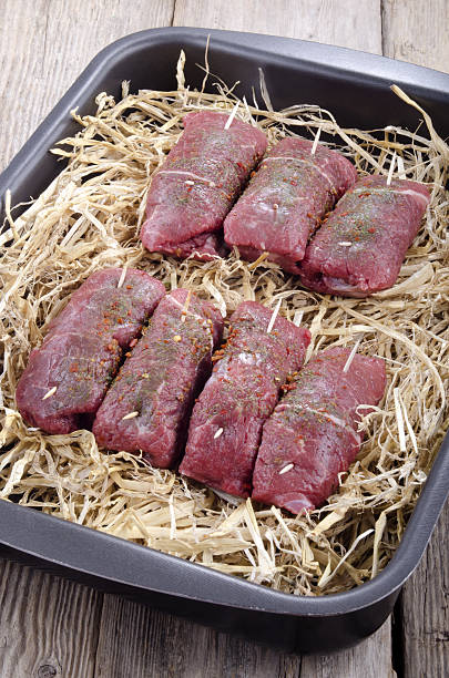 braising steak on a straw bed spicy, raw brasing steak on a straw bed braising pan stock pictures, royalty-free photos & images