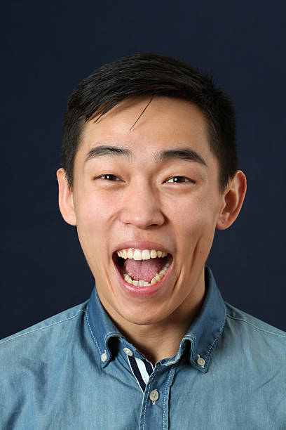 istock Laughing young Asian man looking at camera 470185328
