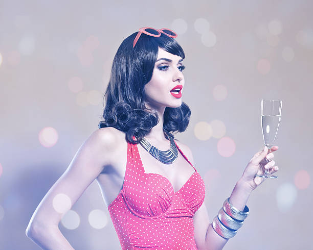 zmysłowy młoda kobieta w czerwony strój kąpielowy trzyma kieliszek do szampana - new years day celebration champagne coloured beige zdjęcia i obrazy z banku zdjęć