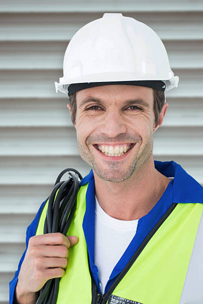 istock Composite image of happy electrician with wire against white background 470193902