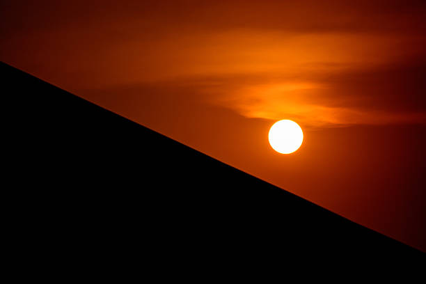 sunset and silhouette roof, focus at sun