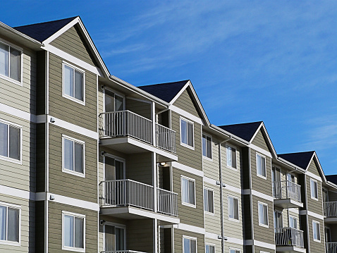 A row of a modern apartment complex development with a bright blue sky.
