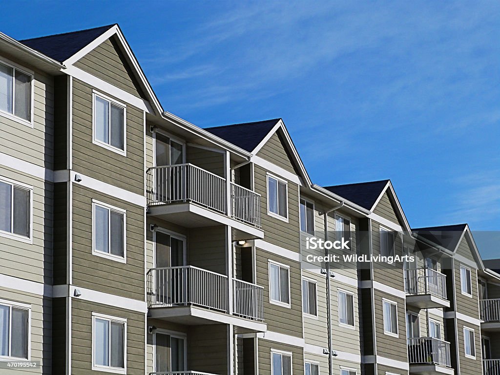 Apartment Complex With Blue Sky A row of a modern apartment complex development with a bright blue sky. Apartment Stock Photo