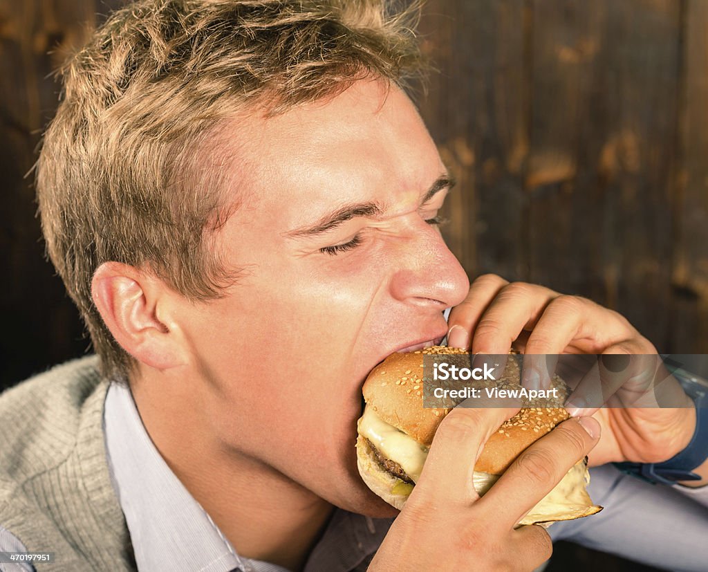 Handsome Man eating Cheeseburger Closed Stock Photo