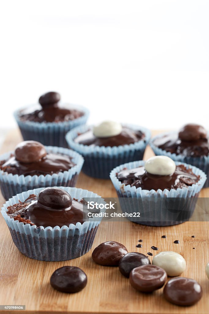 Cupcakes Chocolate cupcakes topped with chocolate sauce and chocolate covered candies. 2015 Stock Photo
